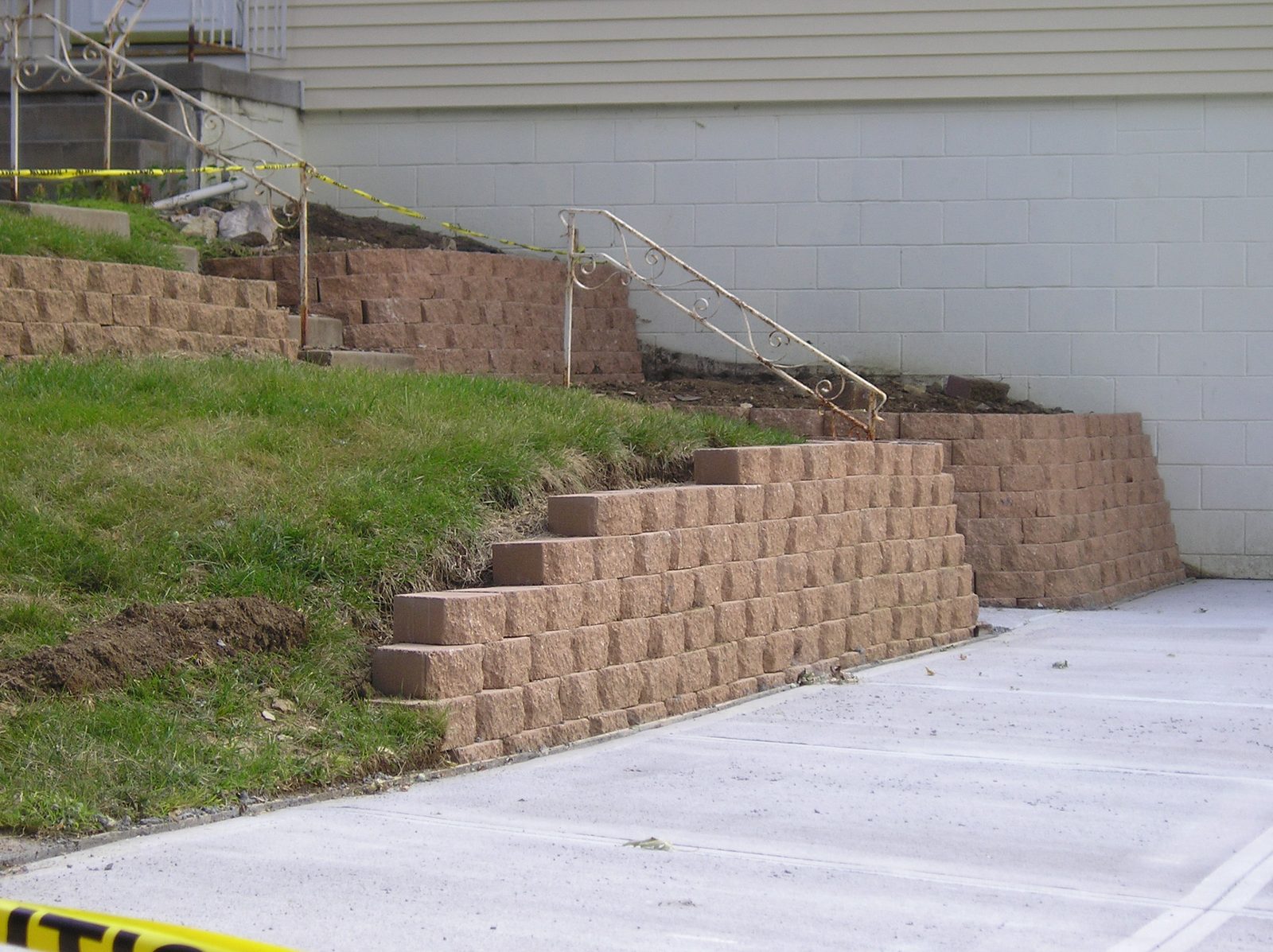 Block retaining wall with steps and concrete driveway